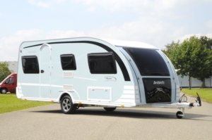 de foto toont een bijzondere caravan op een parkeerplaats Modellen als de Dethleffs Aero Style uit 2012 zijn best een zoektocht waard als je een mooie tweedehands caravan kopen gaat.